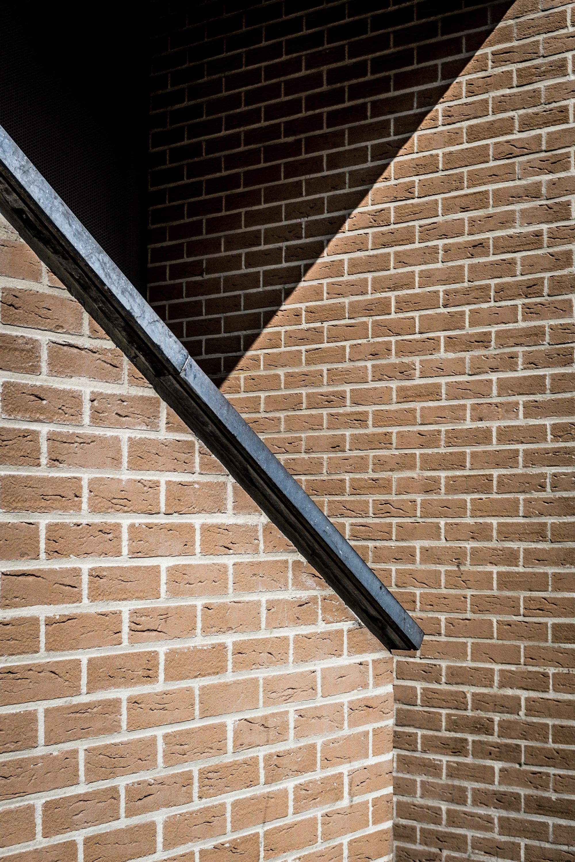 Close view of brickwork meeting a dark steel member at an angle